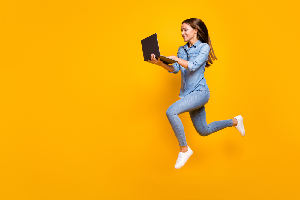 Foto di ragazza che salta con pc in mano