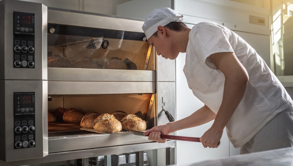 Foto di panettiere che inforna il pane