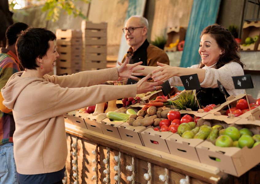 Foto di donna al mercato che saluta una sua amica