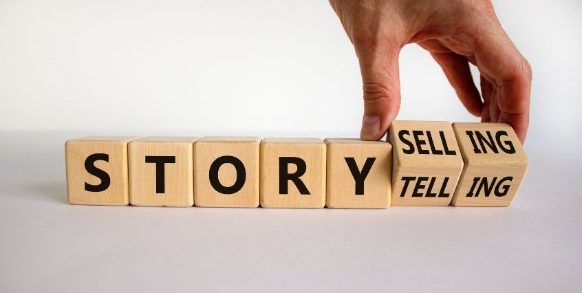 Foto di mano con tessere che compongono parola storytelling
