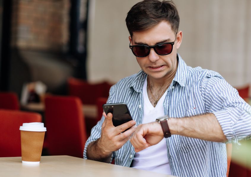 Foto di ragazzo che prende il caffè e guarda l'ora