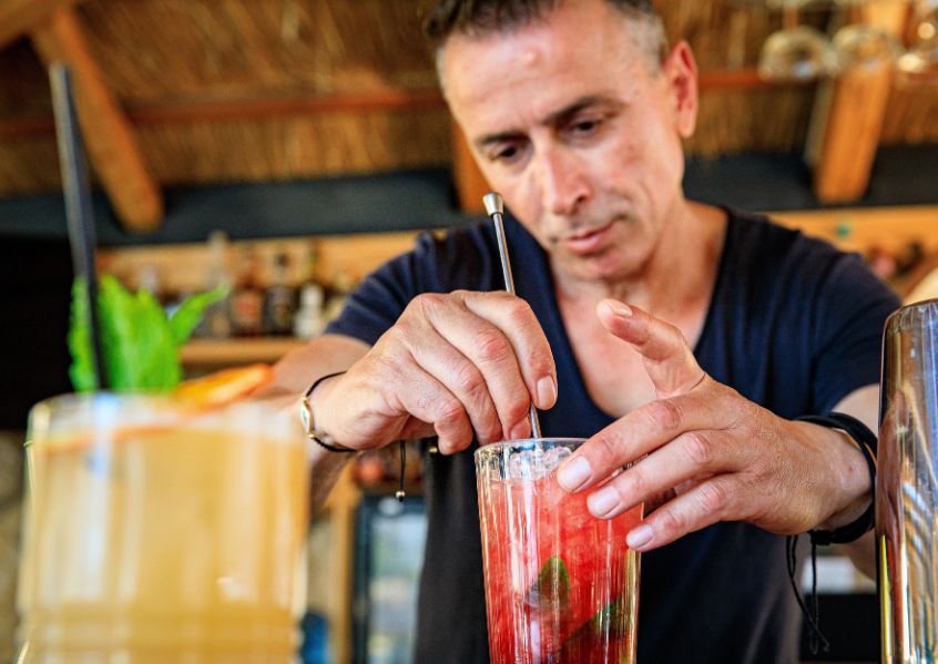 Foto con ragazzo che prepara un cocktail