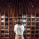 Foto di donna di spalle che guarda la cantina dei vini