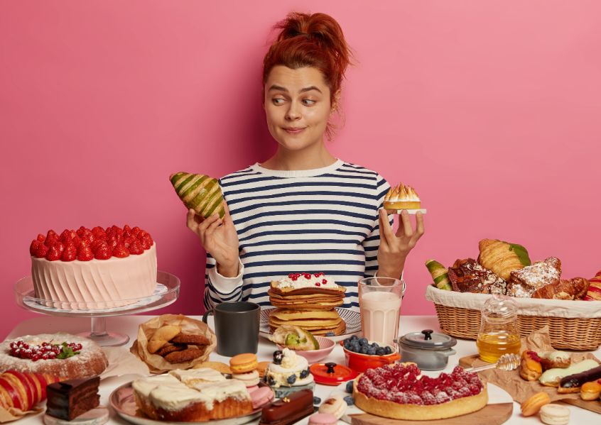 Foto di ragazza dai capelli rossi davanti al buffet dei dolci