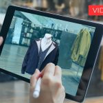 Foto di tablet tenuto in mano in un negozio di vestiti